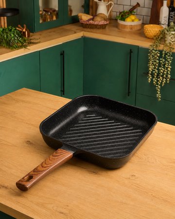 Granova black non-stick grill pan 28 cm cooking grilled food in a modern kitchen